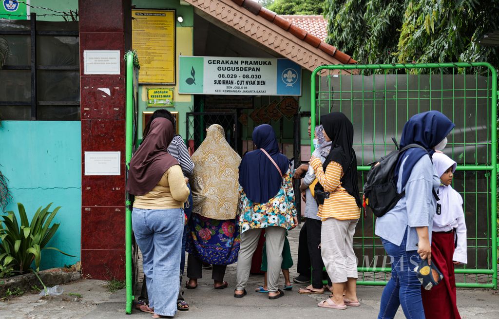 Para orangtua siswa menjemput anak-anak mereka saat pulang sekolah di gerbang SD Negeri Joglo 05, Kembangan, Jakarta Barat, Selasa (31/1/2023). 