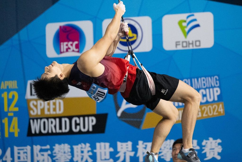 Pemanjat nomor <i>speed </i>China, Peng Wu, merayakan keberhasilan meraih medali emas di seri pertama Piala Dunia Panjat Tebing 2024 di Wujiang, China, Sabtu (13/4/2024).