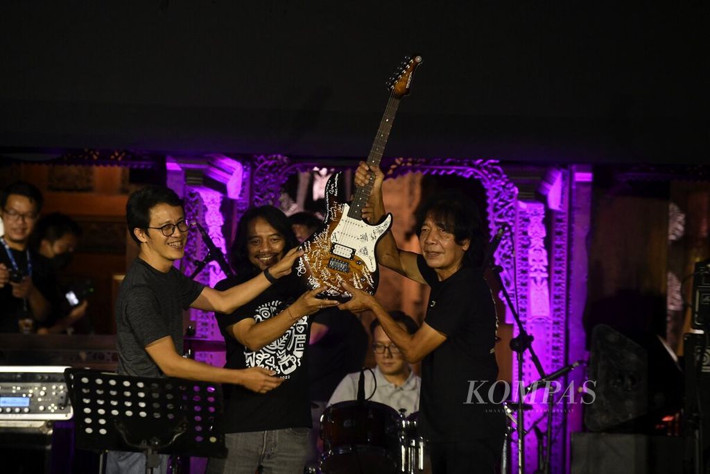 Gitaris Tohpati dan Dewa Budjana menyerahkan gitar kepada Ian Antono secara simbolik dalam konser amal bertajuk "Gitaris untuk Negeri: Donasi Gempa Cianjur", di Bentara Budaya Jakarta, Rabu (7/12/2022). Gitar Yamaha yang sudah ditandatangani oleh puluhan gitaris itu berpindah tangan ke donatur setelah dia menyumbang puluhan juta. 