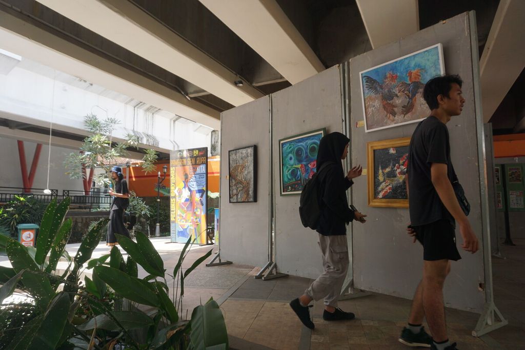 Pengunjung melihat pameran lukisan Dunia Kita, Kanvas Kita di Taman Edukasi Sumber Daya Air di kolong jembatan Jalan Bung Karno, Purwokerto, Banyumas, Jawa Tengah, Minggu (1/10/2023).