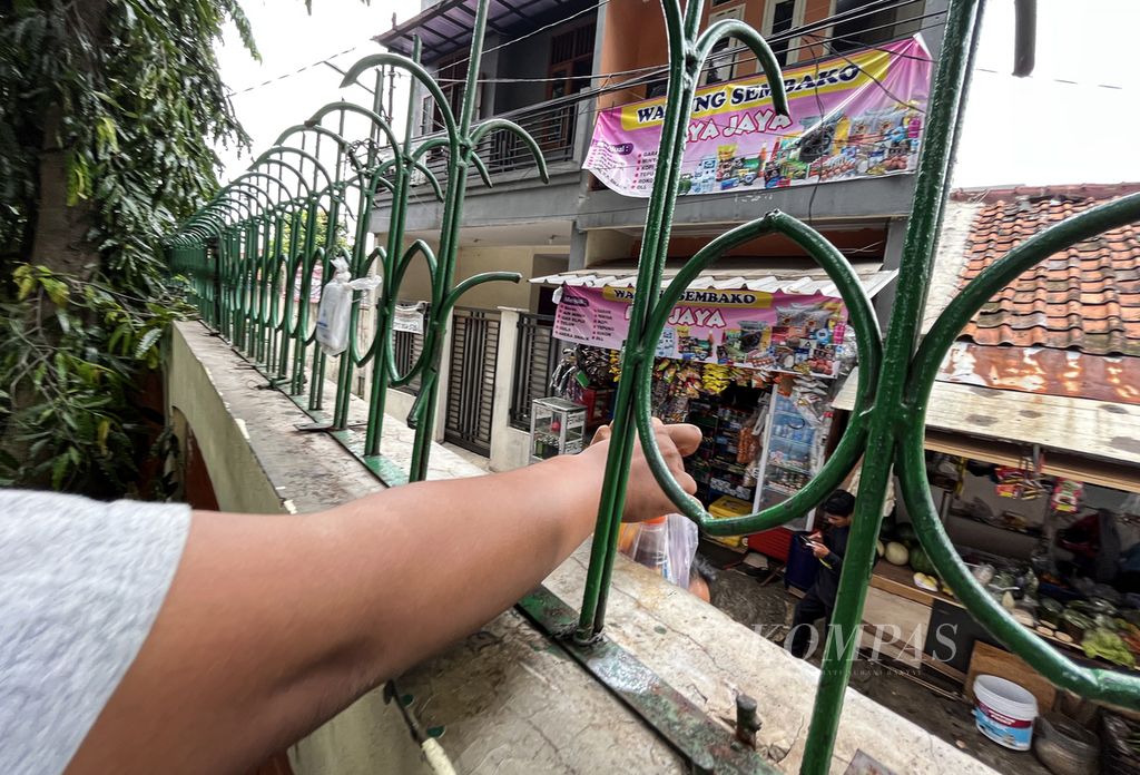 Mahasiswa menerima minuman ringan yang dibeli di warung bel atau warbel dari balik pagar kampus Universitas Islam Negeri Syarif Hidayatullah Jakarta, Tangerang Selatan, Banten, Selasa (8/11/2022). Warung klontong madura tersebut bersiasat dengan berjualan dari balik pagar kampus. SERIAL URBAN KOMING