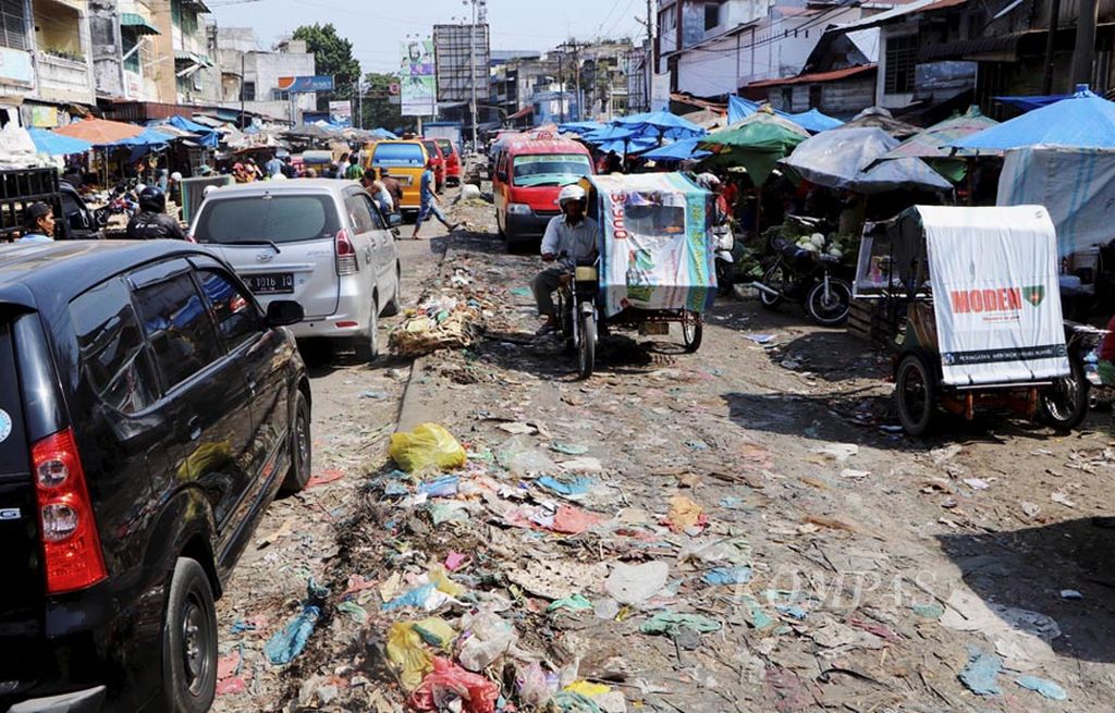 Sampah menumpuk di Jalan AR Hakim, tepatnya  di depan Pasar Sukaramai, Medan, Sumatera Utara, Rabu (26/7). Pedagang dibiarkan berjualan hingga mengokupasi empat dari total enam lajur jalan selama bertahun-tahun. Sementara itu, bangunan resmi pasar kosong.