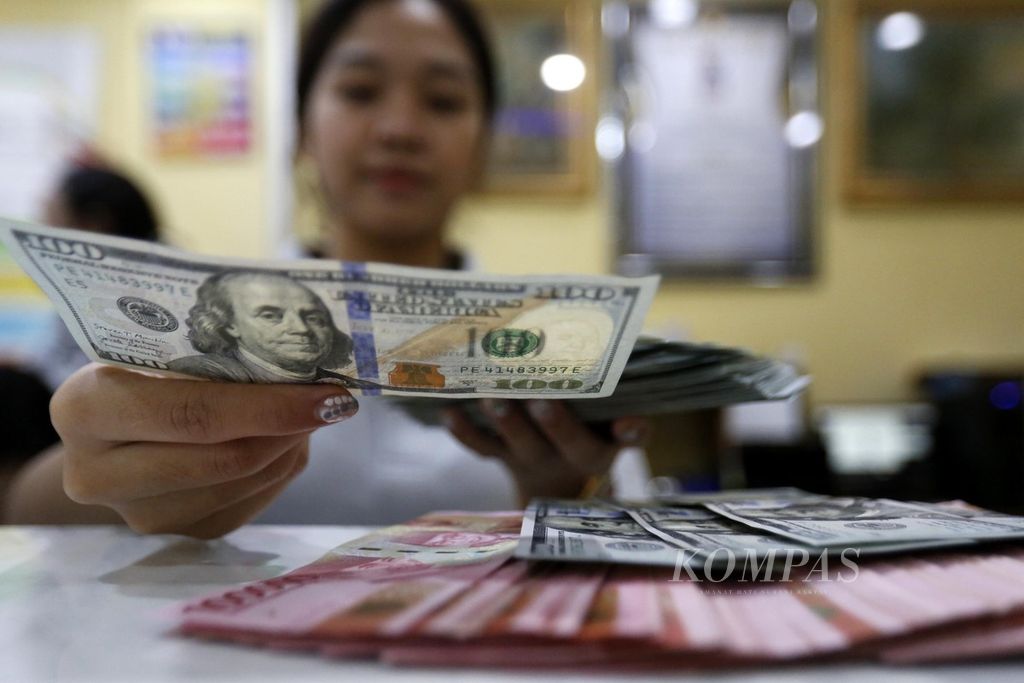 Petugas memeriksa uang dollar AS di tempat penukaran valuta asing Dolarindo di kawasan Blok M, Jakarta Selatan, Jumat (5/3/2021). 