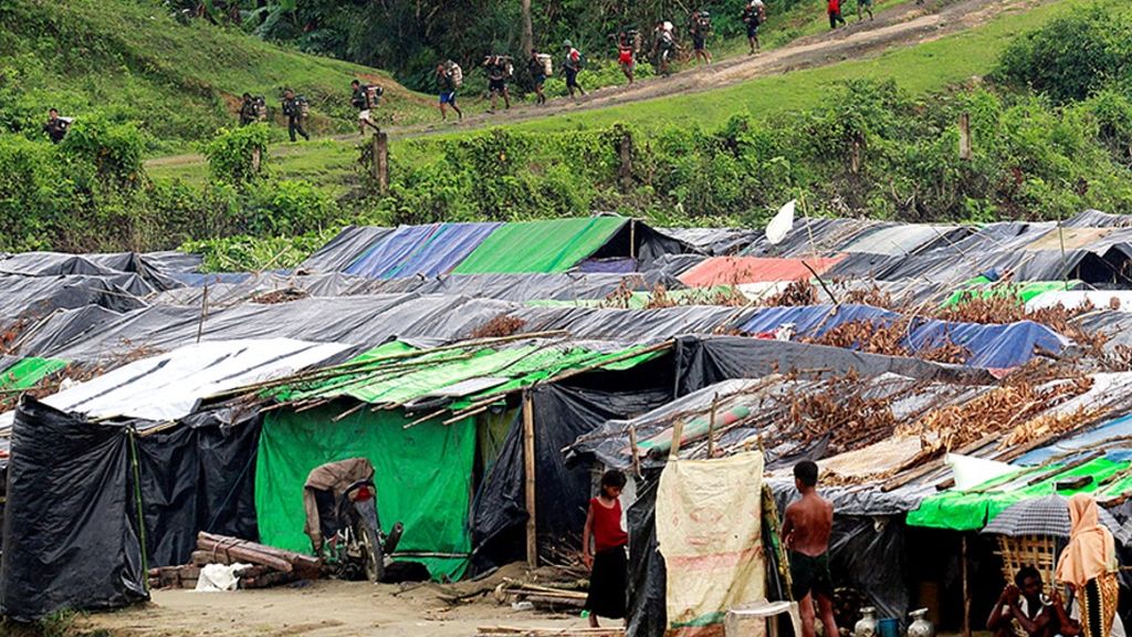 Pengungsi Rohingya berdiri di luar tenda penampungan darurat mereka di perbatasan Bangladesh-Myanmar, ketika pasukan keamanan Myanmar melintasi pagar di Maungdaw, Myanmar pada 9 September 2017.