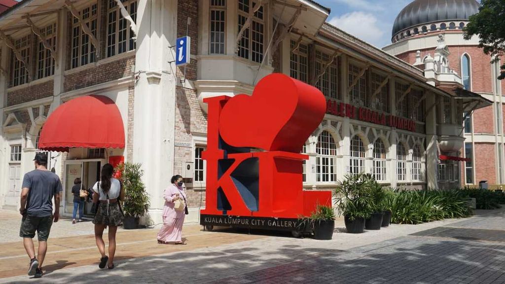 Sejumlah pengunjung berjalan di kawasan Dataran Merdeka, Kuala Lumpur, Malaysia, Jumat (3/6/2022). Antusiasme wisatawan mancanegara untuk masuk ke Malaysia mulai meningkat sejak pintu masuk negara dibuka pada 1 April 2022.