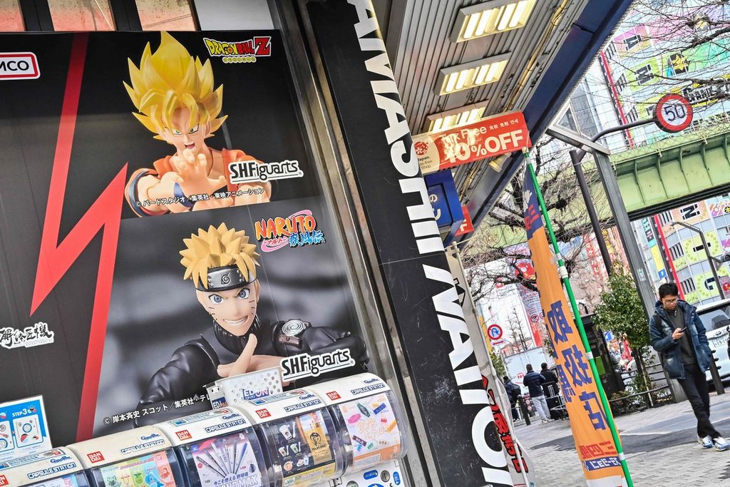 Pejalan kaki melewati poster yang mengiklankan waralaba manga<i> Dragon Ball </i>yang populer di sepanjang jalan di daerah Akihabara, Tokyo, 8 Maret 2024. 