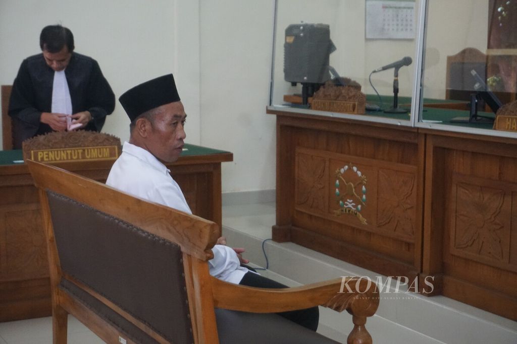 Slamet Tohari (46), terdakwa kasus pembunuhan berencana, uang palsu, penipuan, dan penggelapan, mengikuti persidangan di Pengadilan Negeri Banjarnegara, Jawa Tengah, Kamis (21/12/2023).