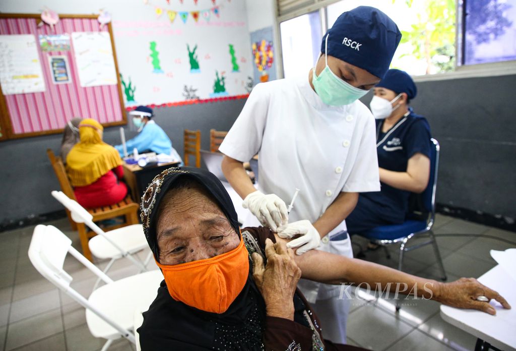 Petugas vaksinator menyuntikkan vaksin Covid-19 dosis pertama ke warga lansia di Sekolah Cinta Kasih Tzu Chi, Cengkareng, Jakarta Barat, akhir Februari 2021. Warga lansia saat ini sudah bisa mendapatkan vaksinasi penguat kedua atau dosis keempat.