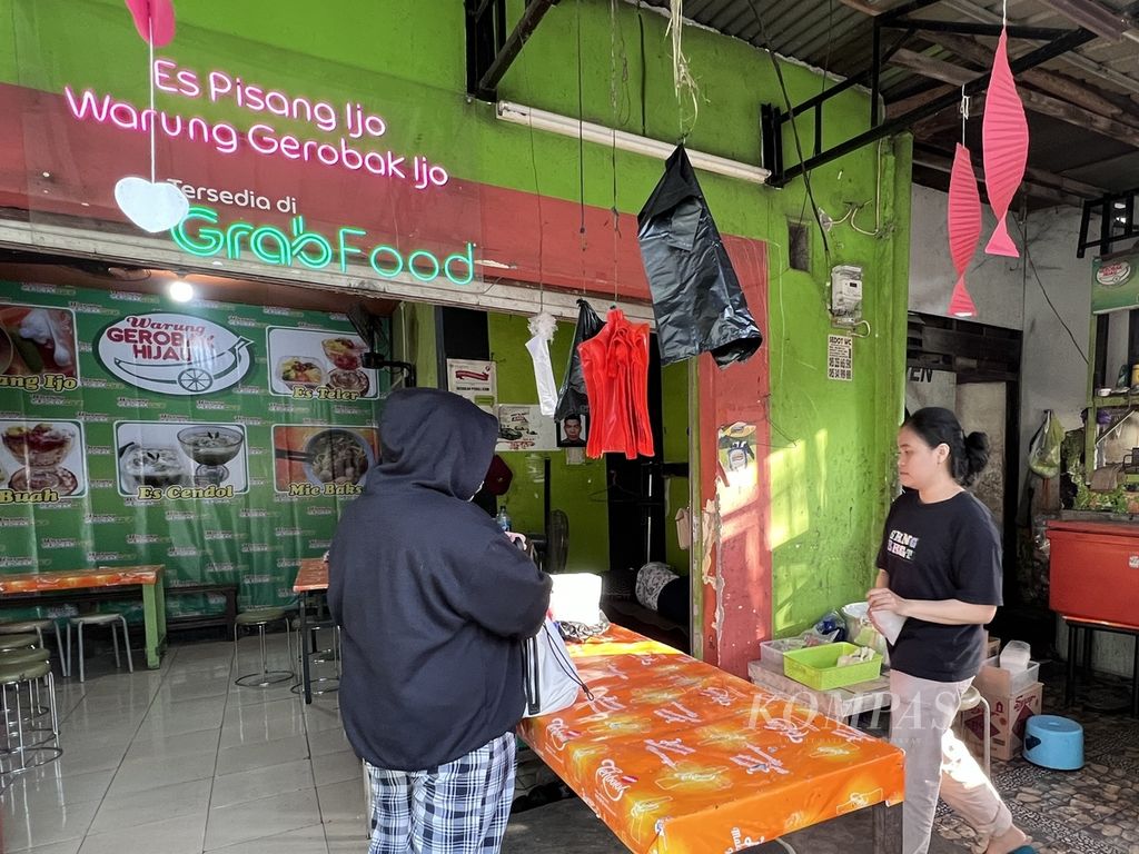 Seorang pembeli memesan es pisang ijo di salah satu warung yang menjual pisang ijo di Makassar, Kamis (5/10/2022).