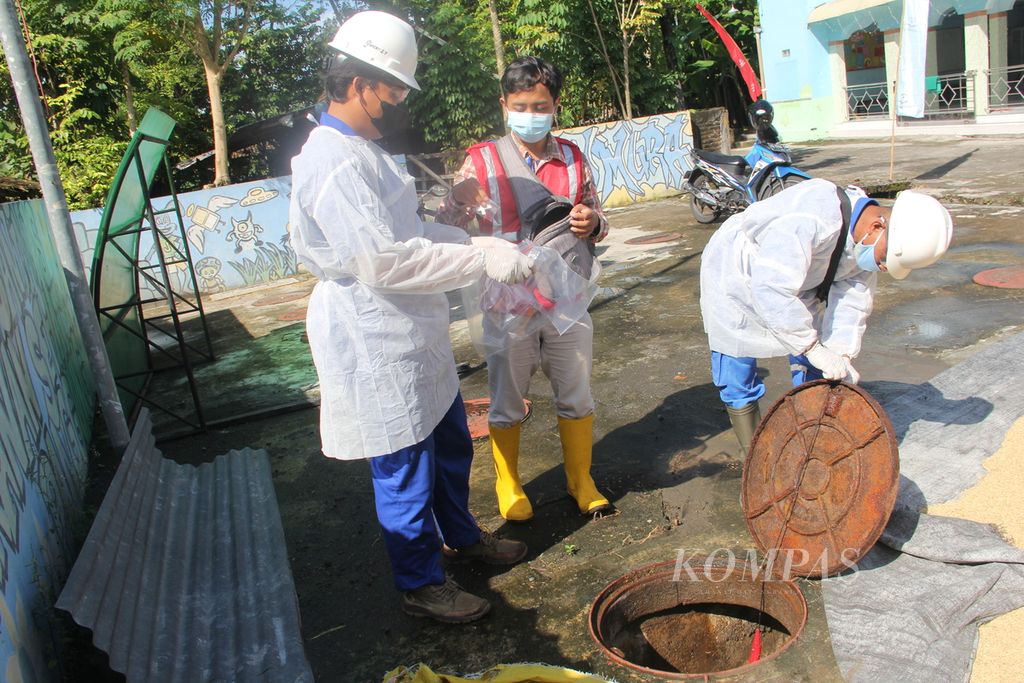 Petugas membuka tutup instalasi pengolahan air limbah (IPAL) komunal di Kabupaten Bantul, Daerah Istimewa Yogyakarta, untuk mengambil alat <i>passive sampler</i> yang berisi sampel air limbah, Rabu (6/4/2022). 
