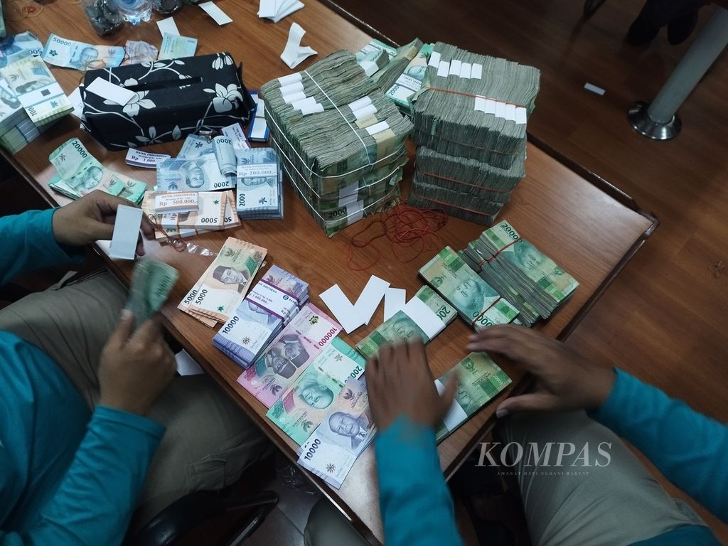 Petugas kasir Bank Indonesia tengah menghitung uang hasil penukaran di Pulau Maratua, Kalimantan Timur, Senin (26/2/2024).
