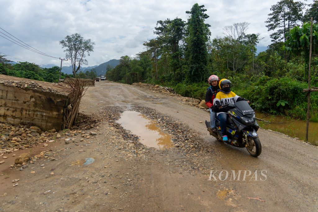 Pengendara menghindari lubang dan konstruksi jalan yang mangkrak di Jalan Trans-Sulawesi di Kecamatan Oheo, Konawe Utara, Sulawesi Tenggara, Sabtu (23/7/2022).