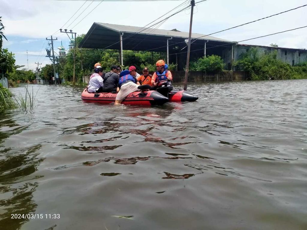 Petugas mengevakuasi warga korban banjir di Kelurahan Trimulyo, Kecamatan Genuk, Kota Semarang, Jawa Tengah, Jumat (15/3/2024) sore.