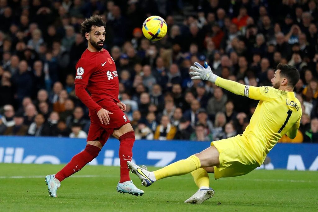Pemain Liverpool, Mohamed Salah, mengecoh kiper Tottenham Hotspur Hugo Lloris untuk mencetak gol pada laga Liga Inggris di Stadion Tottenham Hotspur, London, Minggu (6/11/2022). Liverpool menang dengan skor 2-1. 