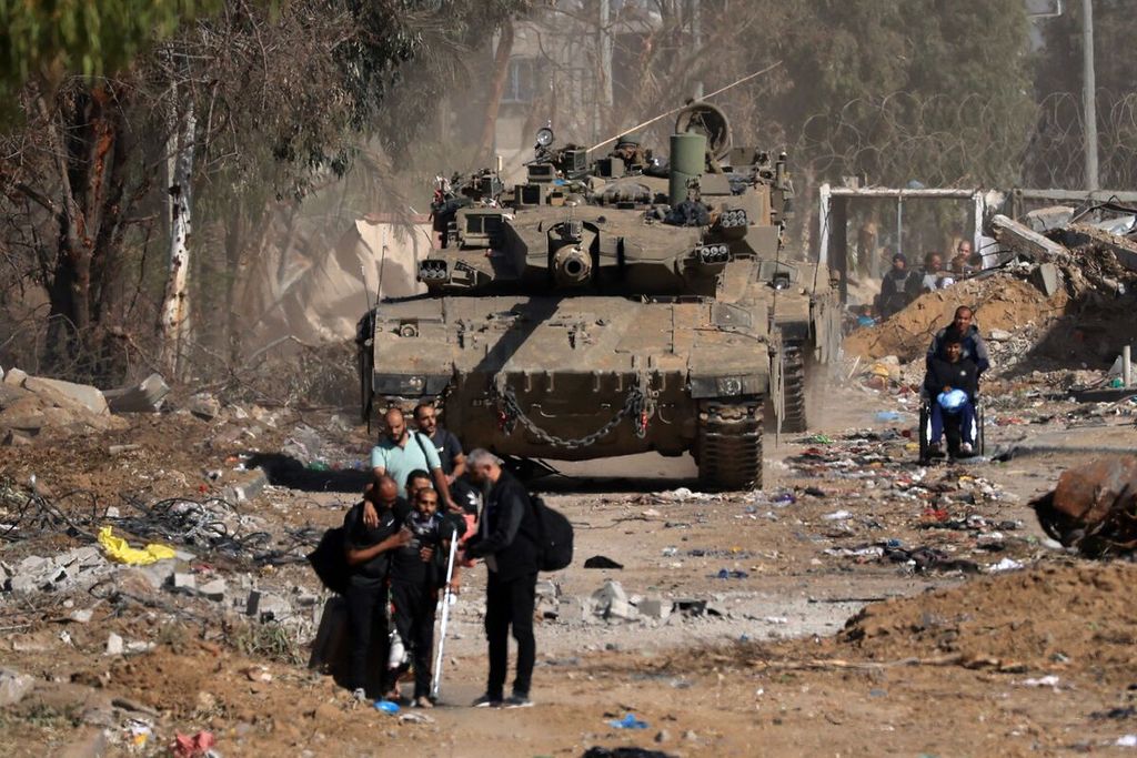 Warga Palestina, termasuk orang-orang yang terluka akibat pengeboman, melewati tank Israel saat mereka melarikan diri ke utara melalui Jalan Salaheddine di Distrik Zeitoun di pinggiran selatan Kota Gaza pada 24 November 2023, setelah empat hari gencatan senjata yang dimulai pada pagi hari. Gencatan senjata dalam perang Israel-Hamas mulai berlaku pada pukul 07.00 (05.00 GMT) dan tampaknya berhasil, berdasarkan kesepakatan pembebasan para sandera dengan imbalan tahanan Palestina.