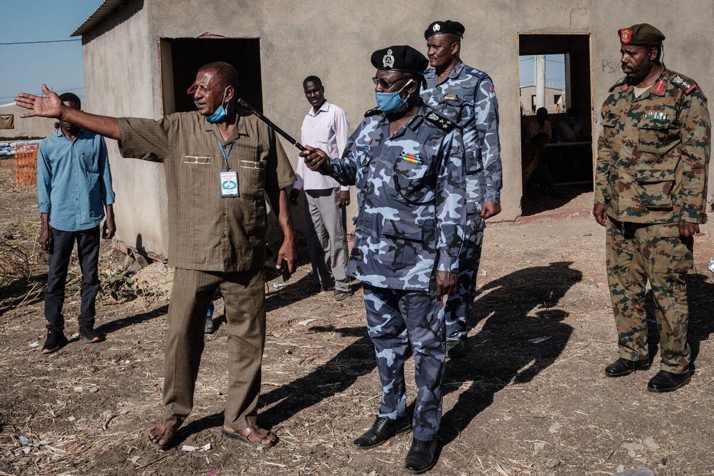 Polisi lokal dan pejabat militer memeriksa pusat transit Village Eight yang menampung para pengungsi Ethiopia yang melarikan diri dari konflik Tigray Ethiopia dekat perbatasan Ethiopia di Gedaref, Sudan Timur, Rabu (2/12/2020).