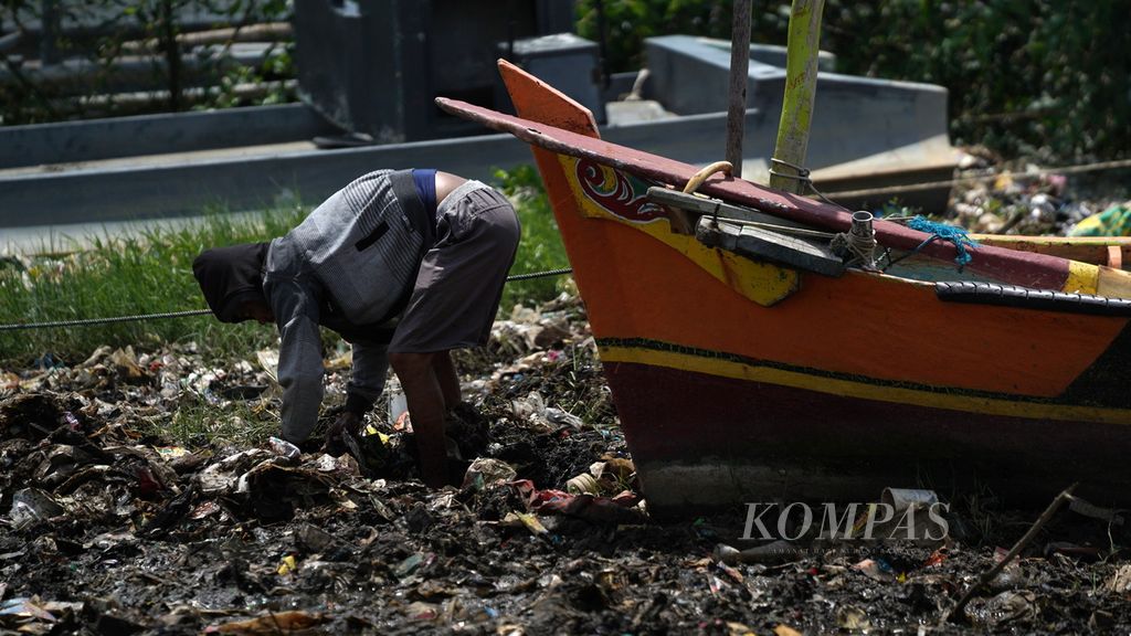 Warga mencari cacing di permukaan muara Kanal Timur yang dipenuhi sampah laut di Marunda Kepu, Cilincing, Jakarta Utara, Selasa (10/1/2023). Sampah berasal dari Kanal Timur dan Teluk Jakarta yang terbawa angin barat. 