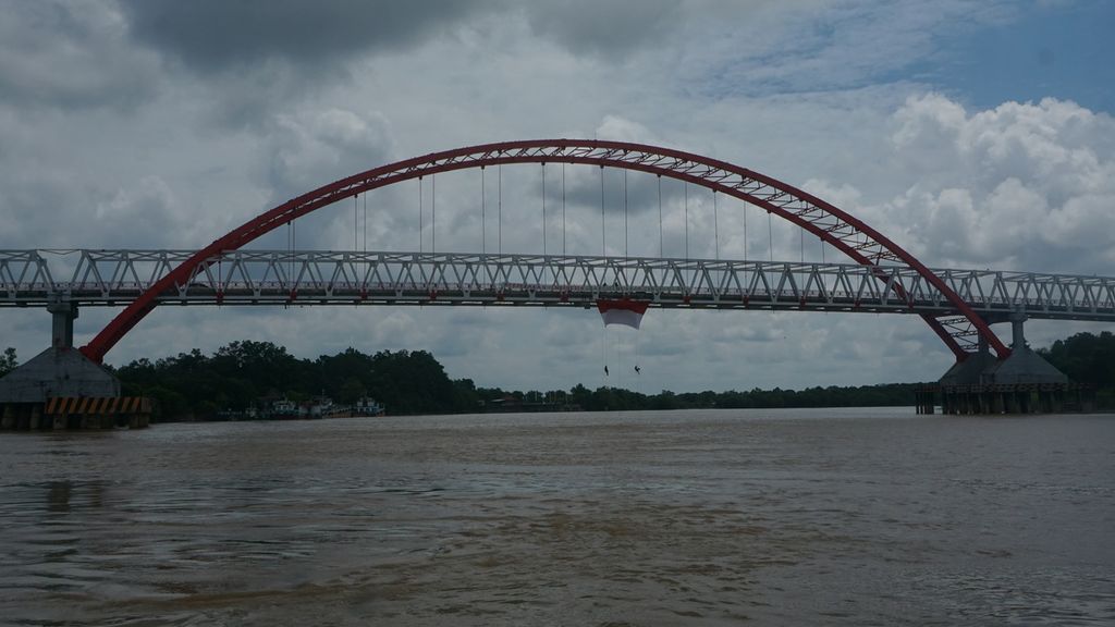 Dua mahasiswa ingin melipat kembali bendera Merah Putih yang mereka pasang di Jembatan Kahayan, Kota Palangkaraya, Kalimantan Tengah, Senin (17/8/2020) sore. Mereka tergabung dari organisasi Mahasiswa Pencinta Alam di berbagai universitas.