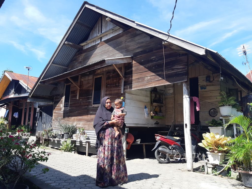 Nur and her mother in front of their house in Beurawe Village, Kuta Alam District, Banda Aceh City, Aceh Province, Wednesday (5/4/2023). Nur experienced slow growth due to unbalanced nutritional intake.