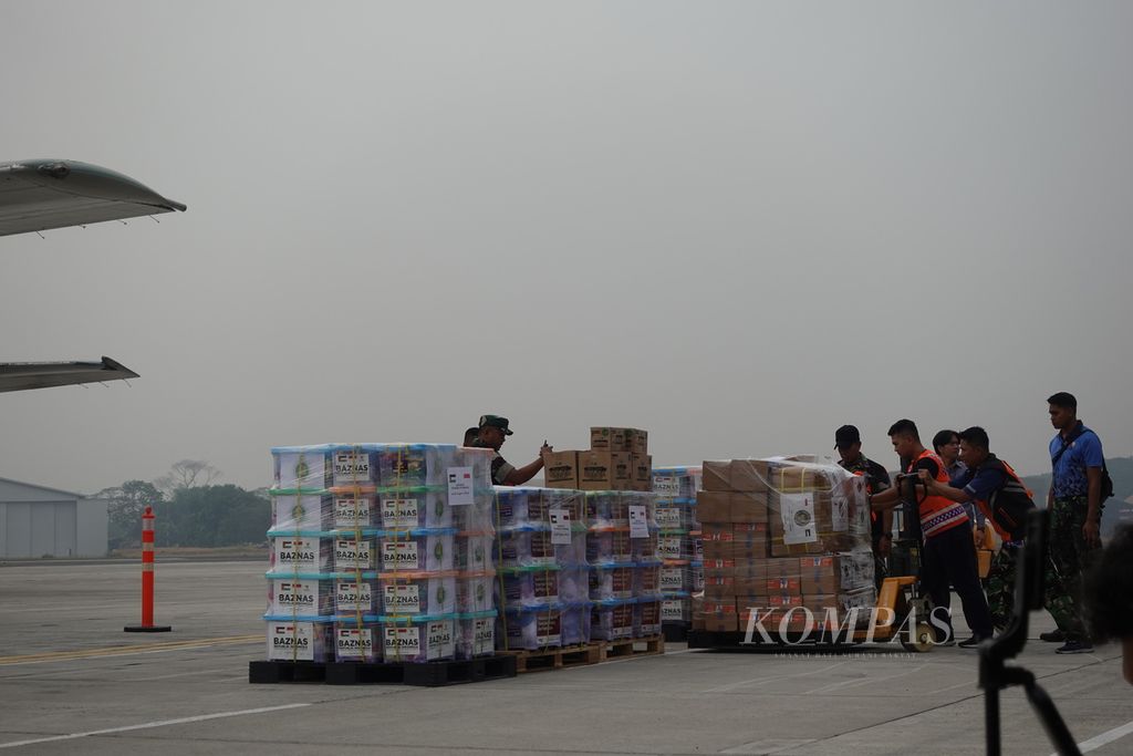 Para petugas bahu-membahu menata bantuan kemanusiaan untuk Palestina yang akan dilepas oleh Presiden Joko Widodo di Pangkalan Tentara Nasional Indonesia Angkatan Udara Halim Perdanakusuma, Jakarta, Sabtu (4/11/2023).