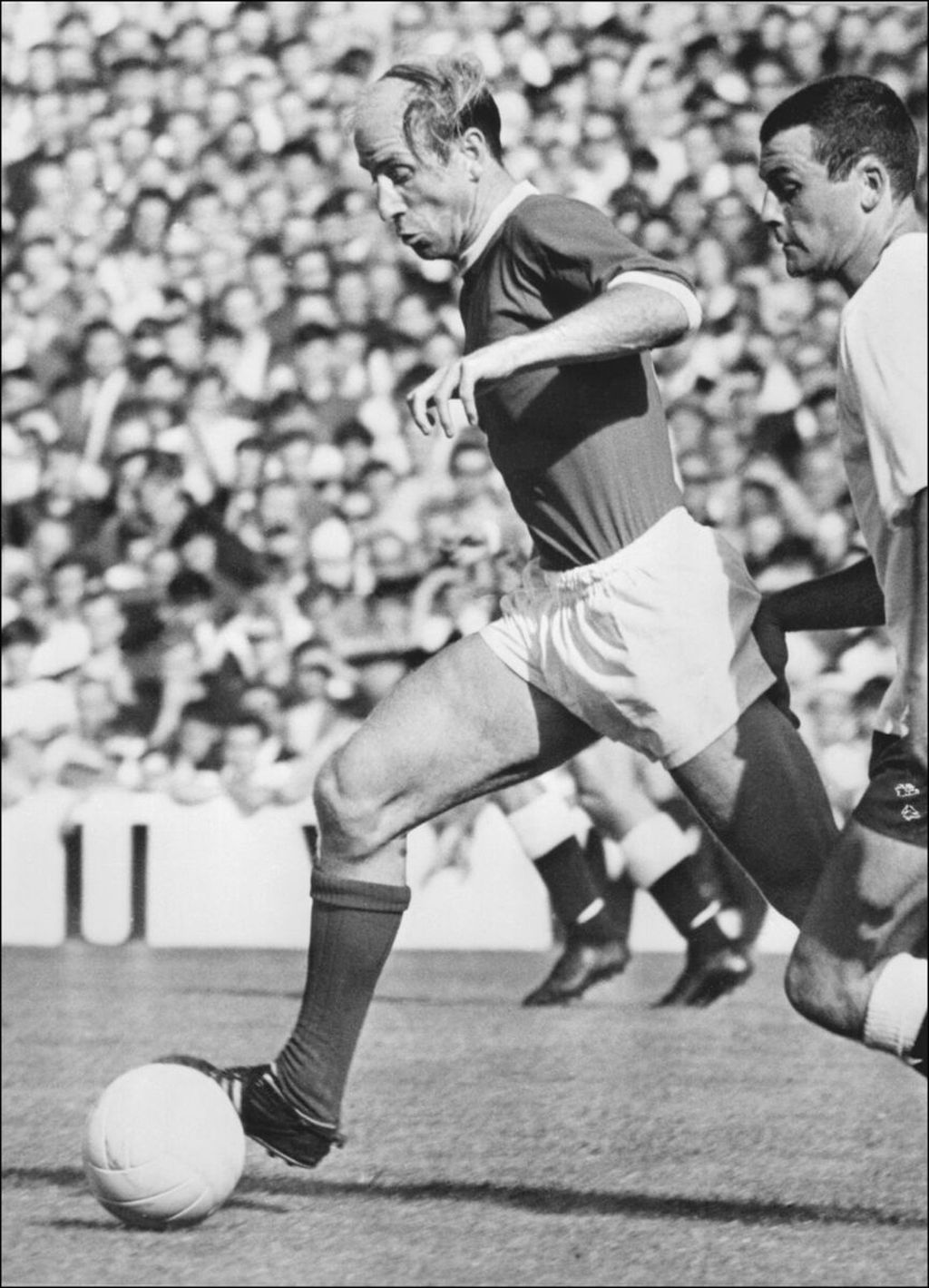 Pemain Inggris, Bobby Charlton, menggiring bola dalam sebuah laga pada 5 Desember 1969 di London. Charlton membawa Inggris memenangi Piala Dunia 1966. 