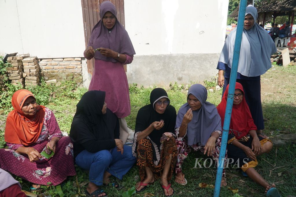 Warga menikmati lamang (lemang) yang mereka masak dalam acara "Malamang Sakampuang" di Kelurahan Aie Pacah, Kecamatan Koto Tangah, Kota Padang, Sumatera Barat, Sabtu (31/12/2022). 