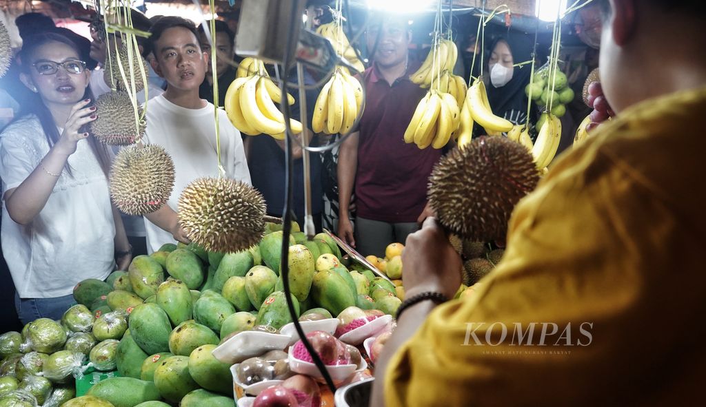 Calon wakil presiden Gibran Rakabuming Raka bersama istrinya, Selvi Ananda, memilih buah saat mengisi hari berkampanyenya dengan mengunjungi Pasar Rawasari, Cempaka Putih, Jakarta, Minggu (3/12/2023). 