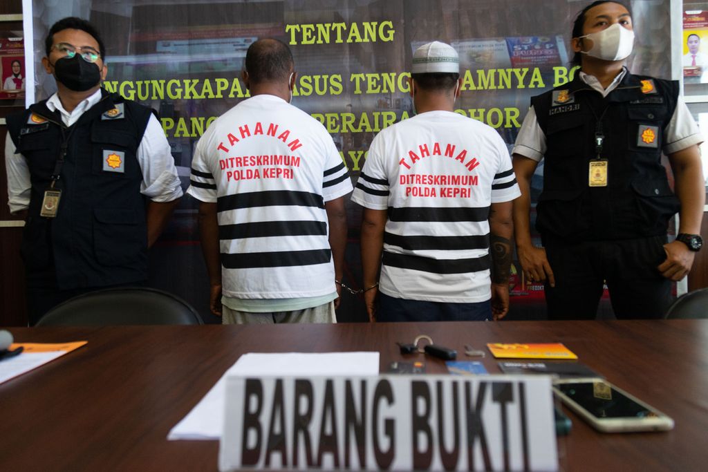 Dua anggota sindikat perdagangan orang yang terlibat dalam penyelundupan 64 pekerja migran yang menjadi korban dalam kecelakaan perahu tenggelam di perairan Johor, Malaysia, dihadirkan polisi saat rilis pers di Markas Polda Kepulauan Riau, Batam, Senin (27/12/2021).