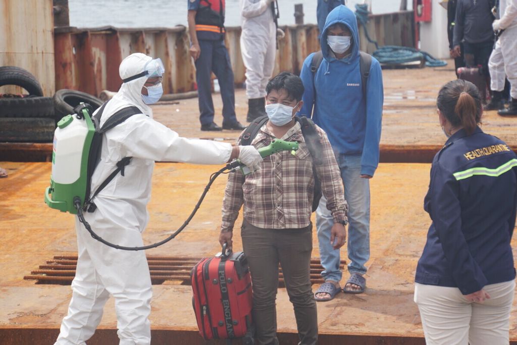 Seorang anak buah kapal disemprot disinfektan sesaat setelah tiba di dermaga Pelabuhan Samudra Bitung, Sulawesi Utara, Sabtu (7/11/2020). Sebanyak 155 ABK dan dua jenazah direpatriasi dari kapal-kapal perikanan China setelah terkatung-katung di laut sejak pandemi Covid-19 merebak.