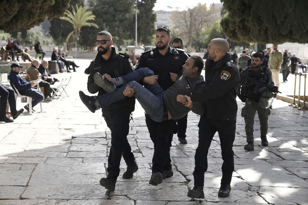 Seorang laki-laki warga Palestina digotong oleh beberapa aparat keamanan Israel dan dibawa ke luar kompleks Mesjid Al-Aqsa, Jerusalem, Rabu (5/4/2023). Untuk kedua kalinya, aparat keamanan Israel menyerbu ke dalam kompleks Masjid Al Aqsa dan mengusir warga Palestina yang tengah beribadah.