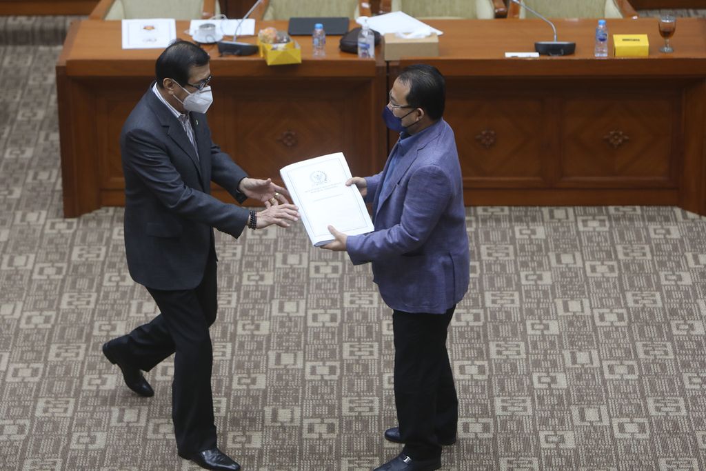 Wakil Ketua Komisi III DPR Pangeran Khairul Saleh (kanan) menyerahkan daftar inventaris masalah (DIM) RUU Hukum Acara Perdata kepada Menteri Hukum dan HAM Yasonna Laoly saat rapat kerja di Kompleks Gedung Parlemen, Senayan, Jakarta, Rabu (16/2/2022). 