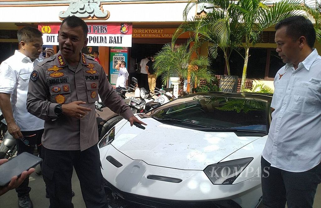 Kepala Bidang Humas Polda Bali Komisaris Besar Stefanus Satake Bayu Setianto (kiri) menunjukkan mobil jenis <i>supercar</i> yang diamankan di Polda Bali, Kota Denpasar, Senin (13/3/2023).