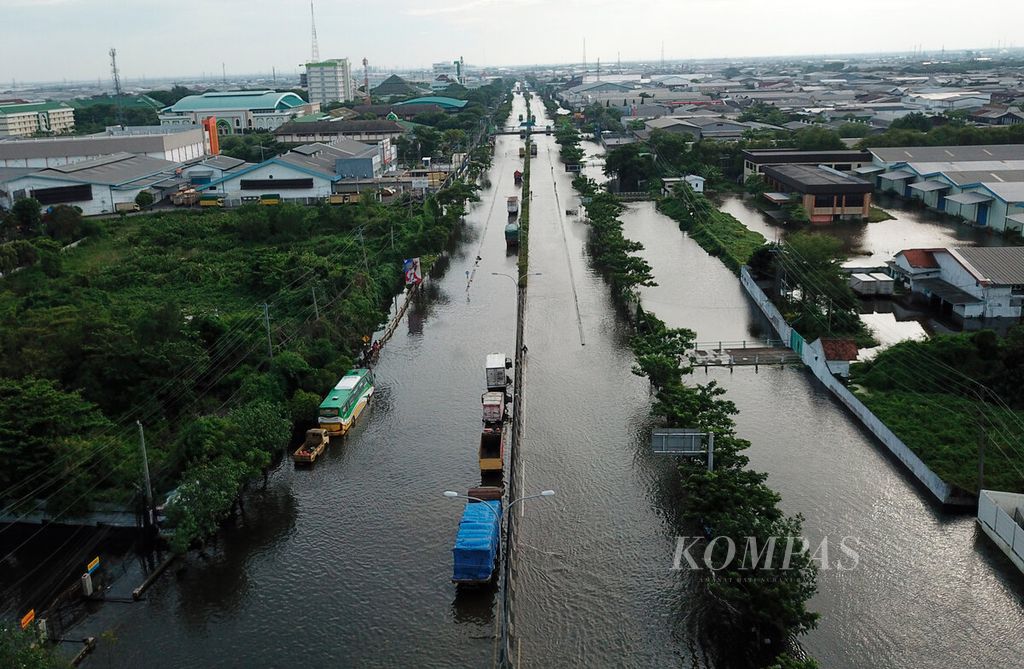 Jalan pantura sebagai akses utama pelintasan barang dan jasa yang dalam tiga hari ini masih lumpuh karena banjir di Kaligawe, Kota Semarang, Jawa Tengah, Senin (2/1/2023). 