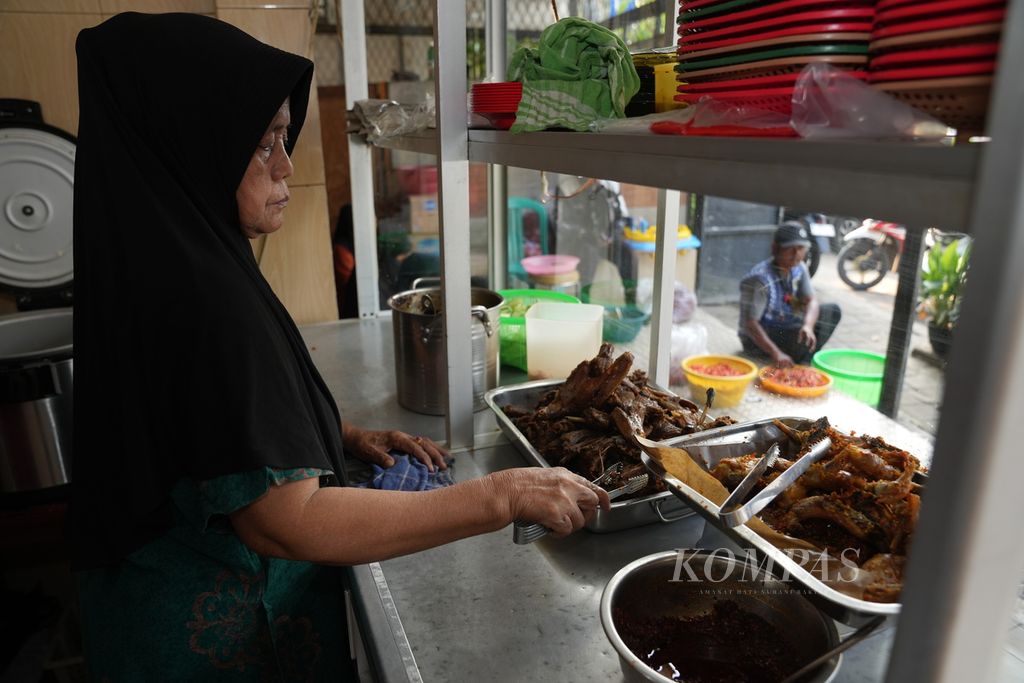  AIsa (67) melayani pembeli di Warung Nasi Bebek Ma’Isa 1, Jalan Bekasi Timur, Pulo Gadung, Jakarta Timur, Senin (29/7/2024). Warung itu berdiri sejak 1991. Warung dengan 15 pekerja tersebut tiap hari menghabiskan 200 hingga 300 bebek.