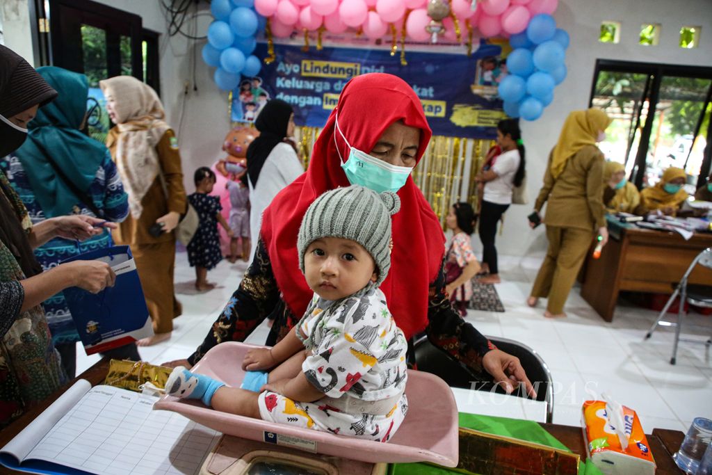 Kader posyandu memeriksa perkembangan berat badan seorang anak balita yang mengikuti kegiatan Pekan Imunisasi Dunia 2023 di Posyandu Eri/Kenanga I, Kecamatan Cipondoh, Kota Tangerang, Banten, Senin (8/5/2023).