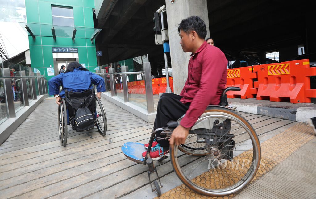 Penyandang difabel mendorong kursi roda menuju lift Stasiun MRT Lebak Bulus, Jakarta Selatan, setelah peresmian area parkir khusus kendaraan penyandang disabilitas, Kamis (20/2/2020). 