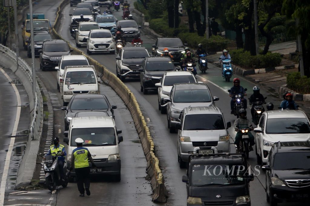 Polisi pengatur lalu lintas menghentikan kendaraan yang menerobos jalur Transjakarta di Jalan Letjen S Parman, Jakarta, Jumat (8/12/2023). Pelanggaran serupa masih kerap terjadi karena minimnya kesadaran tertib berlalu lintas para pengguna jalan. 