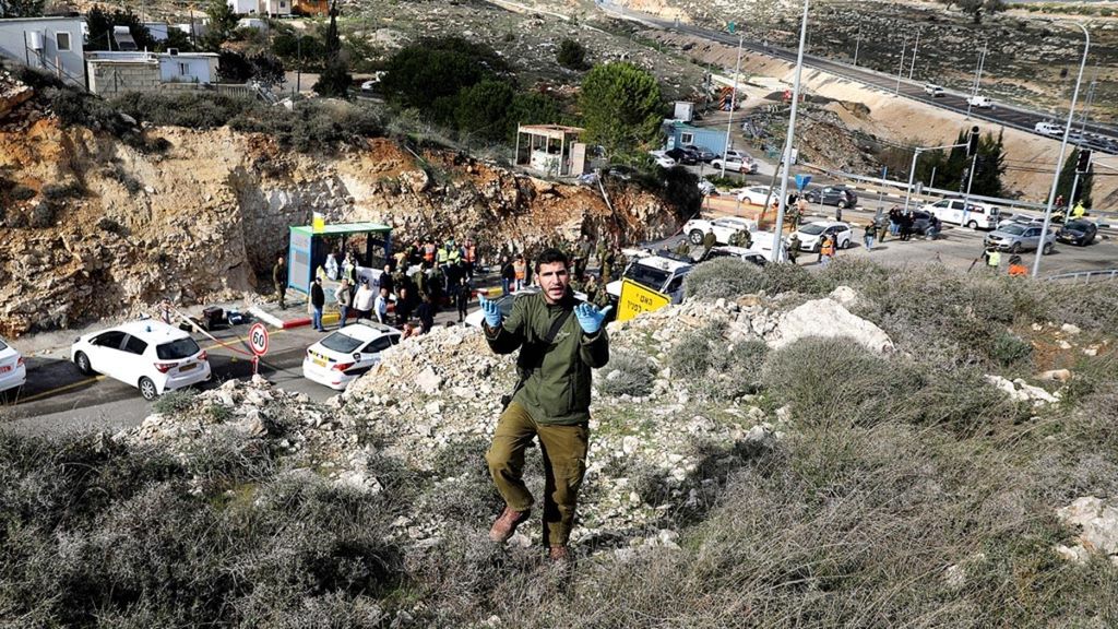 Seorang tentara Israel berjalan membelakangi lokasi serangan penembakan di dekat Ramallah, wilayah pendudukan Tepi Barat, 13 Desember 2018. Otoritas Israel terus memperluas wilayah permukiman Yahudi ilegal di Tepi Barat.