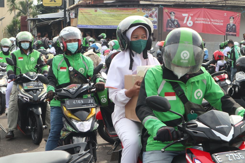 Pengendara Gojek mengantar para tenaga kesehatan dalam peringatan Hari Pahlawan di Markas Polres Cirebon Kota, Jawa Barat, Rabu (10/11/2021). 