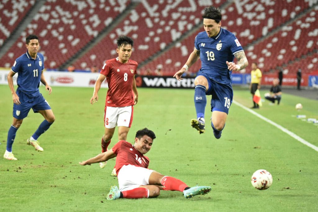 Pesepak bola tim nasional Indonesia, Asnawi Mangkualam (kedua kanan), menghalau bola dari pesepak bola timnas Thailand, Tristan Do (kanan), dalam pertandingan babak final laga pertama Piala AFF 2020 di Stadion Nasional, Singapura, Rabu (29/12/2021). 