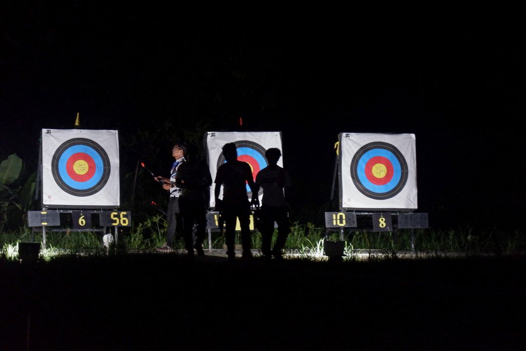 Para pemanah tim Indonesia mengambil anak panah dari papan target dalam sesi latihan malam hari pada Jumat (29/3/2024) di D’khayangan Archery Center, Bekasi, Jabar.