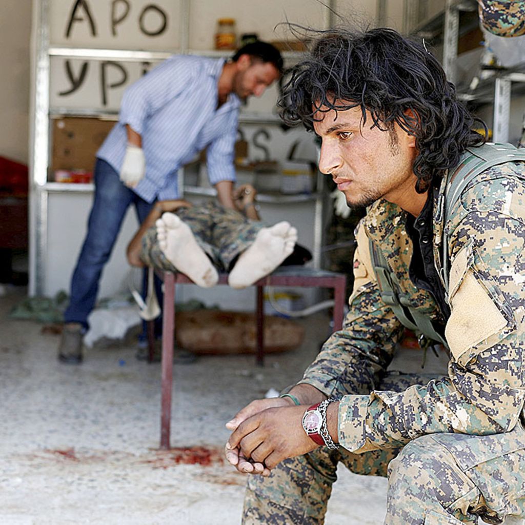  Seorang tentara Pasukan Demokratik Suriah (SDF) menunggui rekannya yang tengah diobati setelah ditembak oleh petembak runduk Negara Islam di Irak dan Suirah (NIIS) di Raqqa, Suriah, 28 Juni 2017.