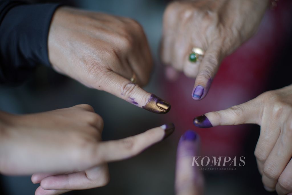 Warga menunjukkan jari yang sudah dicelupi tinta seusai menggunakan hak pilihnya dalam Pemilu 2024 di tempat pemungutan suara di Kelurahan Pondok Kelapa, Duren Sawit, Jakarta Timur, Rabu (14/2/2024). 