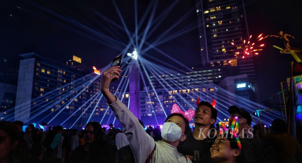Warga berswafoto di kawasan Bundaran Hotel Indonesia, Jakarta, saat merayakan Tahun Baru 2024, Senin (1/1/2024).  
