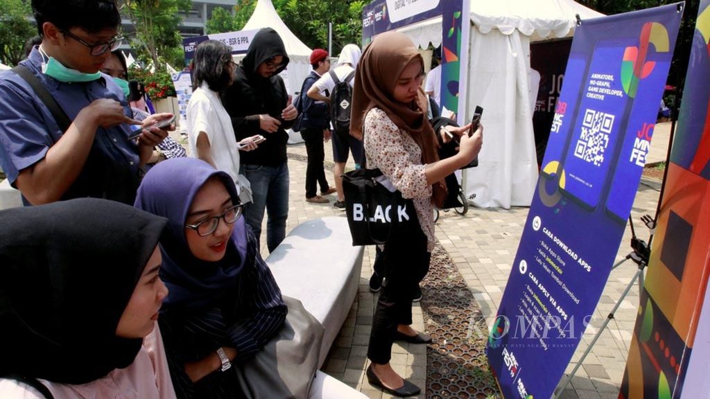 Job seekers scan the barcode of the job service link at the job fair held at the MNC Festival Job Fair, Jakarta, on  Sunday (11/3/2019).
