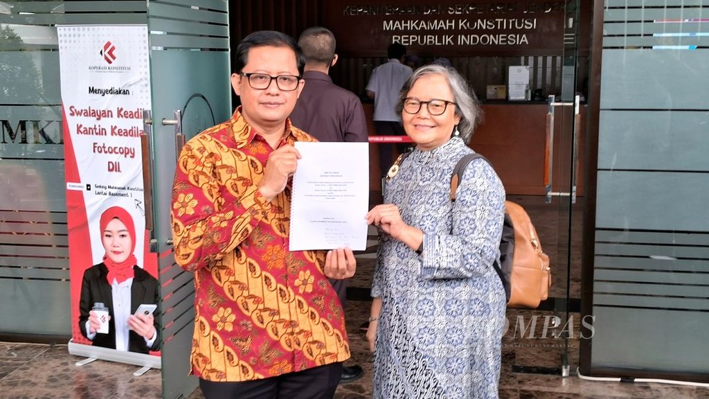 Akademisi Universitas Negeri Jakarta, Ubedilah Badrun (kiri), dan Guru Besar Antropologi Hukum Universitas Indonesia Sulistyowati Irianto menunjukkan berkas <i>amicus curiae</i> yang disampaikan ke Mahkamah Konstitusi, Kamis (28/3/2024).