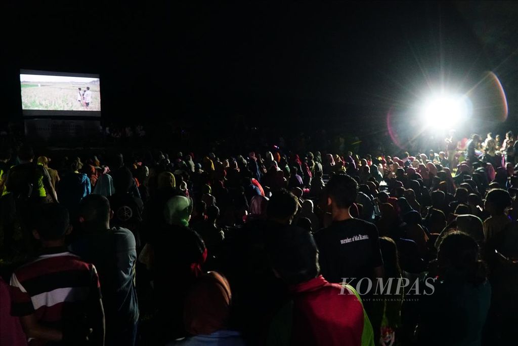 Warga Desa Karangtalun, Purbalingga, Jawa Tengah, berbondong-bondong menonton film layar <i>tanjleb</i> atau layar tancap pada pembukaan Festival Film Purbalingga, Sabtu (6/7/2019) malam, di lapangan desa.