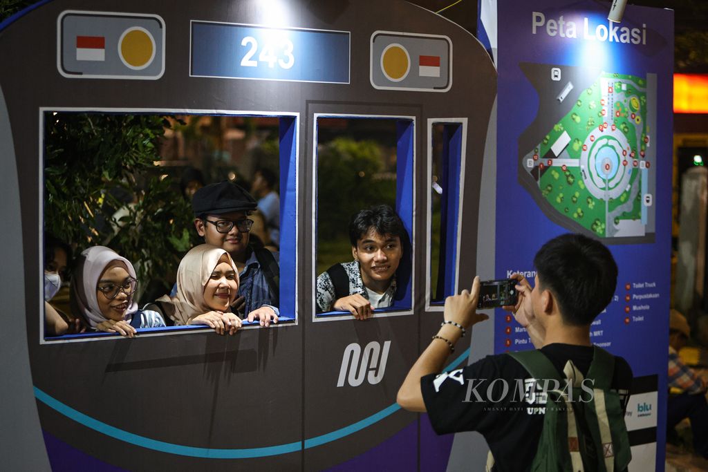 Visitors take photos together while attending the MRT Day Festival at the Marta Christina Tiahahu Literacy Park, South Jakarta, Sunday (24/3/2024).