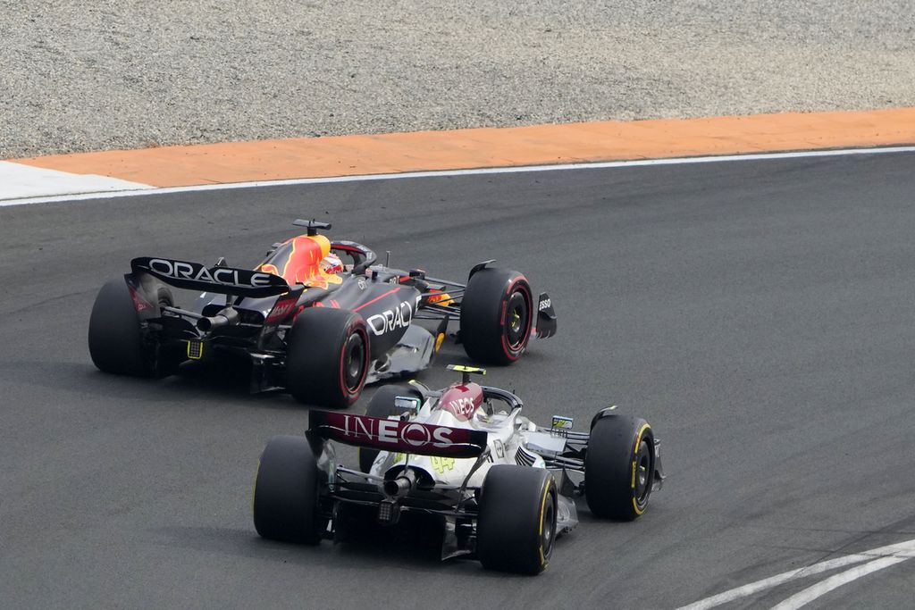 Pebalap Red Bull Max Verstappen (kiri) ditempel oleh pebalap Mercedes Lewis Hamilton saat melewati tikungan pada balapan Grand Prix Formula 1 seri Belanda di Sirkuit Zandvoort, Belanda, Minggu (4/9/2022). Hamilton gagal meraih podium di seri Belanda. 