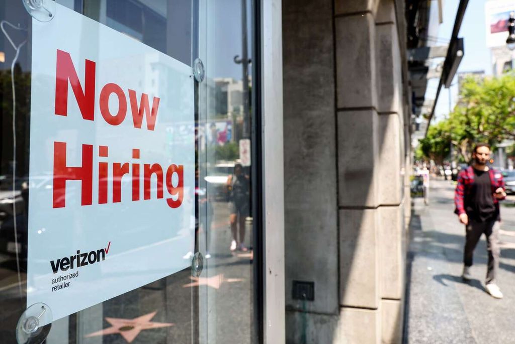 Tanda pengumuman "Now Hiring", yang memperlihatkan lowongan pekerjaan, dipajang di bagian depan pertokoan Verizon di Los Angeles, California, AS, 26 Juli 2022. 